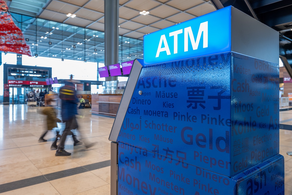 Berliner Volksbank vending machine. In the background, people walk through the check-in hall