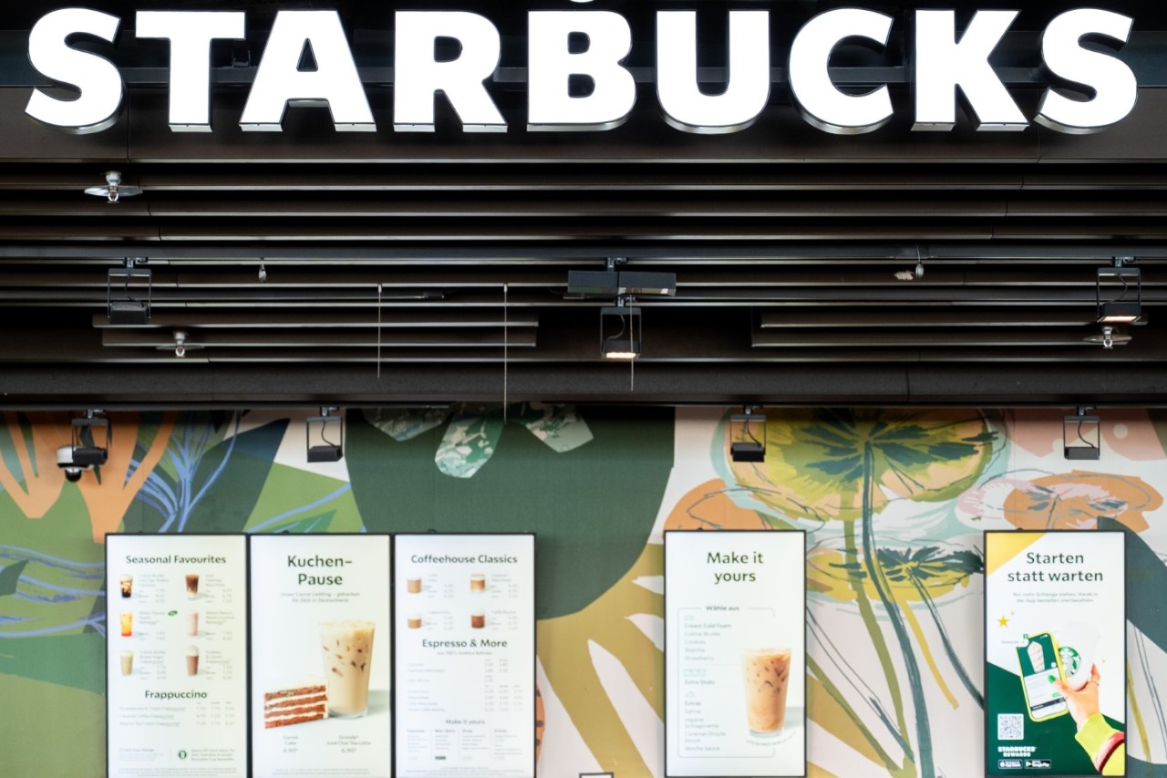 View of the “Starbucks” sign above the store. Below it, boards with offers.
