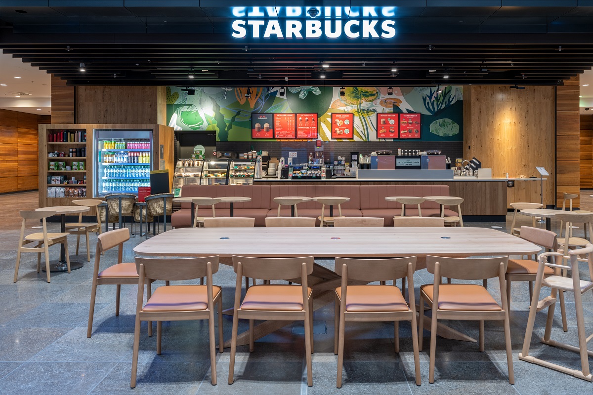View of the Starbuchs store. Seating in the foreground. The bar in the background.