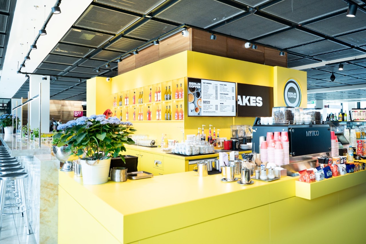 A Coffee Bar in yellow and black inside Terminal 1.