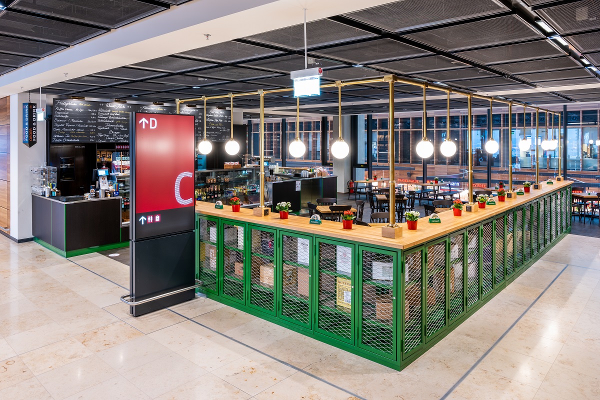 View of the Lagner Bräu from outside. A green enclosure. Lamps illuminate the restaurant.