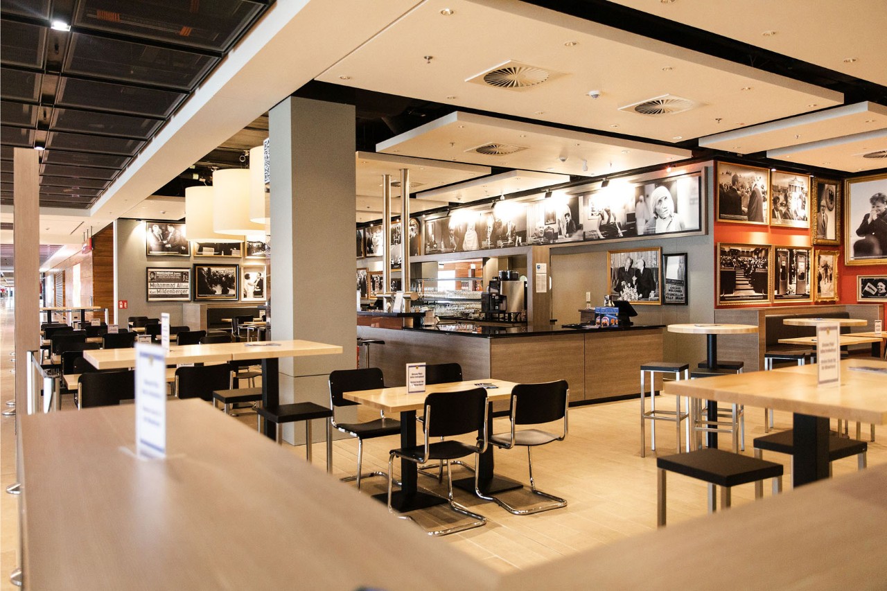 View of the Permanent Representation. In the foreground the seating, in the background the bar with pictures on the wall.