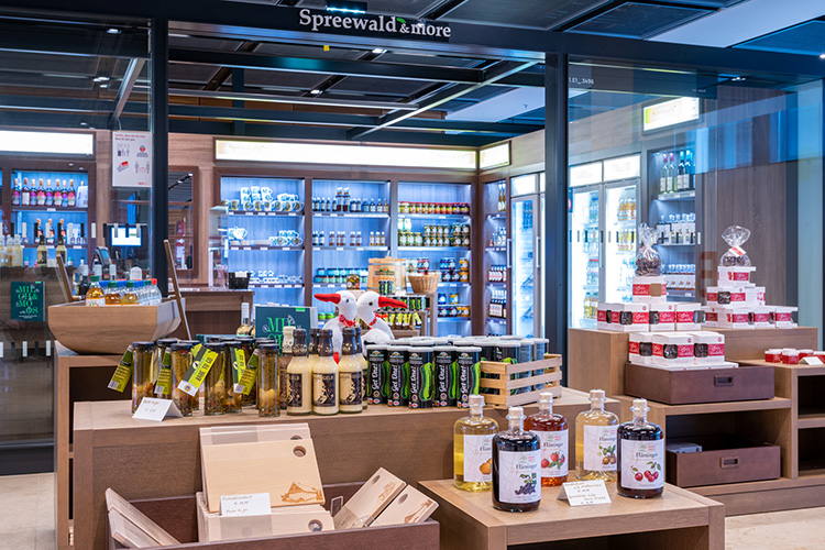 View of the store display with pickle jars and schnapps. Refrigerated shelves in the background.