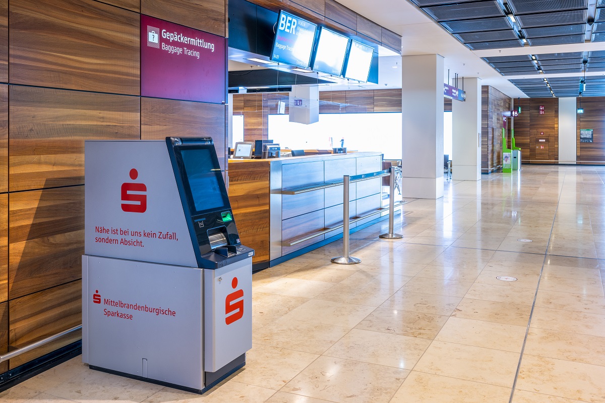 Gray machine of the Mittelbrandenburgische Sparkasse. In the background: baggage tracing.