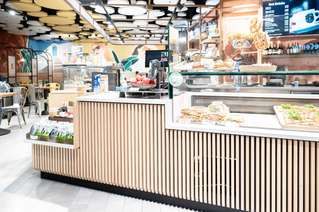 Counter of the NU Café Casa with a modern, Mediterranean design. Behind it the seating area.