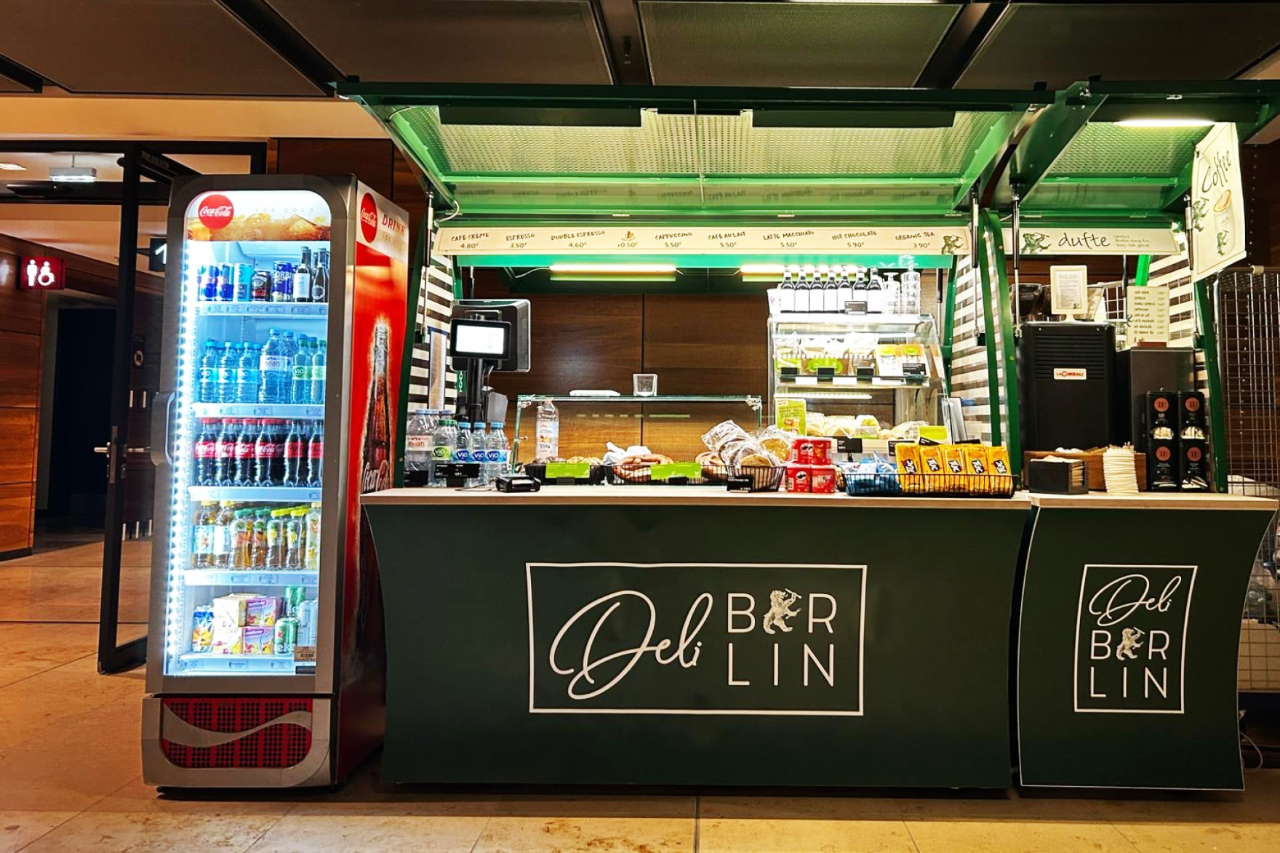 Mobile stand with food and drink. Next to it a drinks fridge.