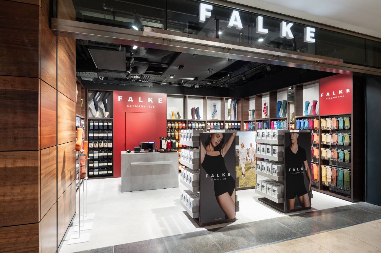 View of the Falke store from outside. Hosiery on display and wall shelves.