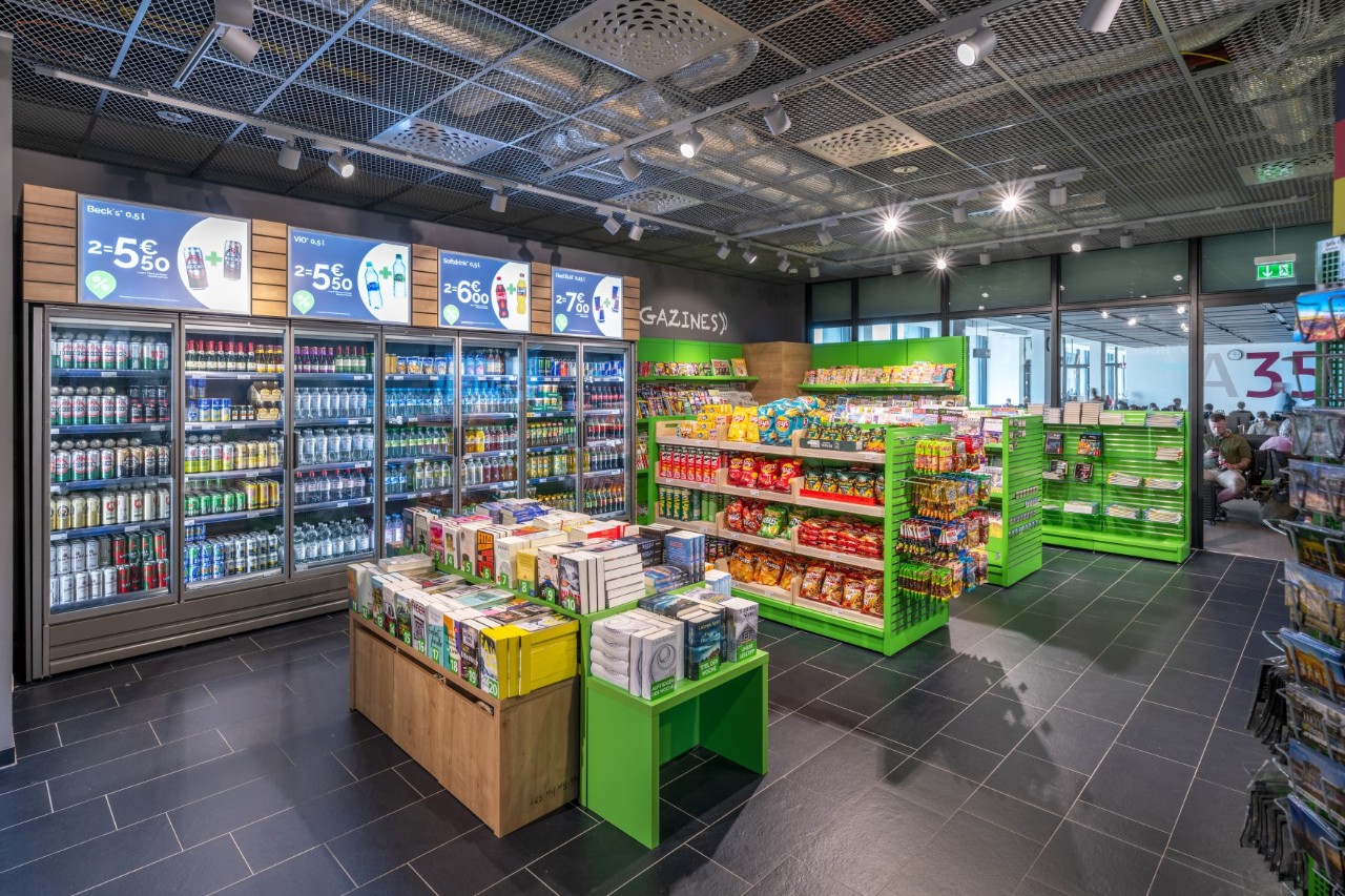 Interior view with green shelves with drinks and food.