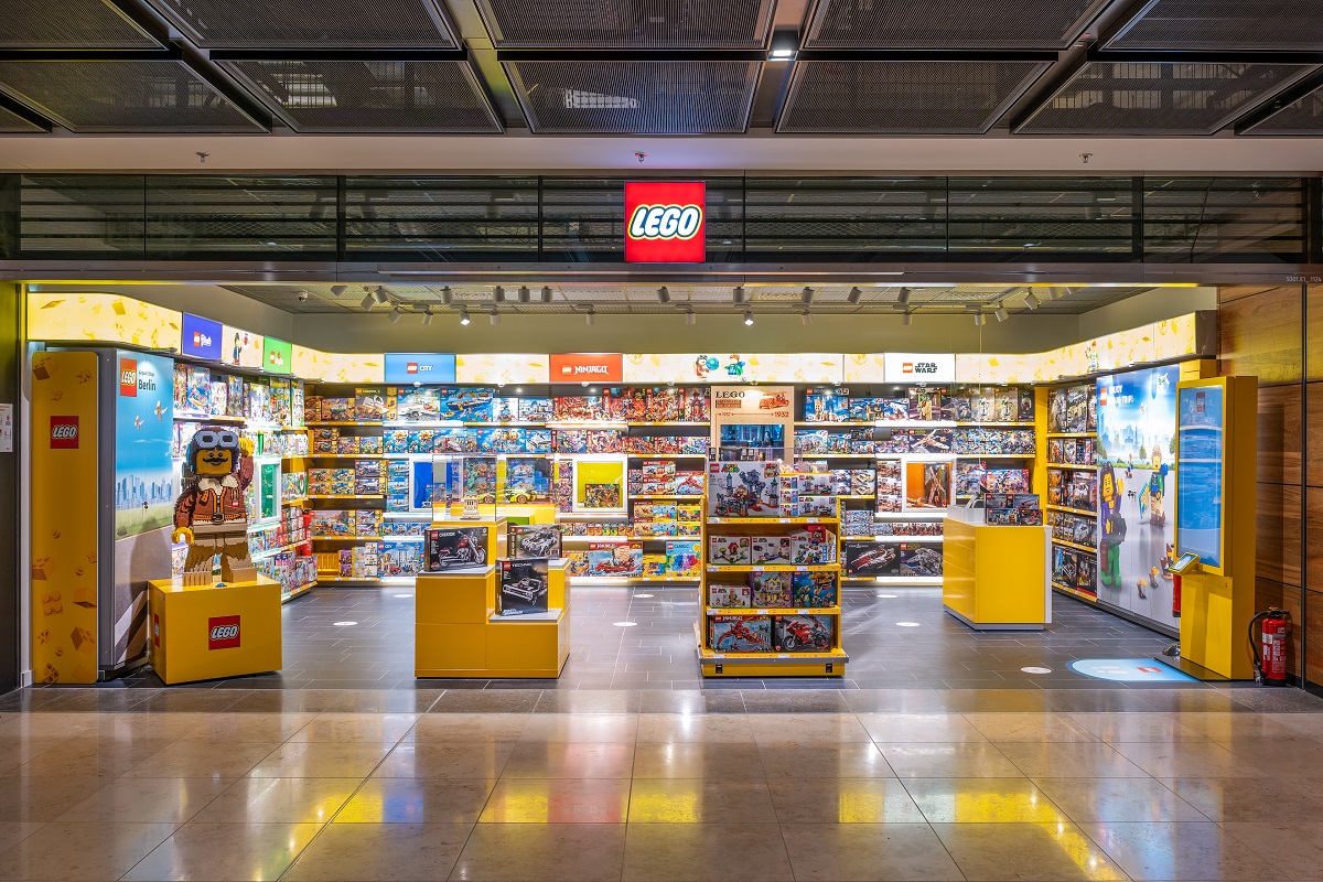 View from outside into the Lego store with play sets on the counter and on wall shelves.