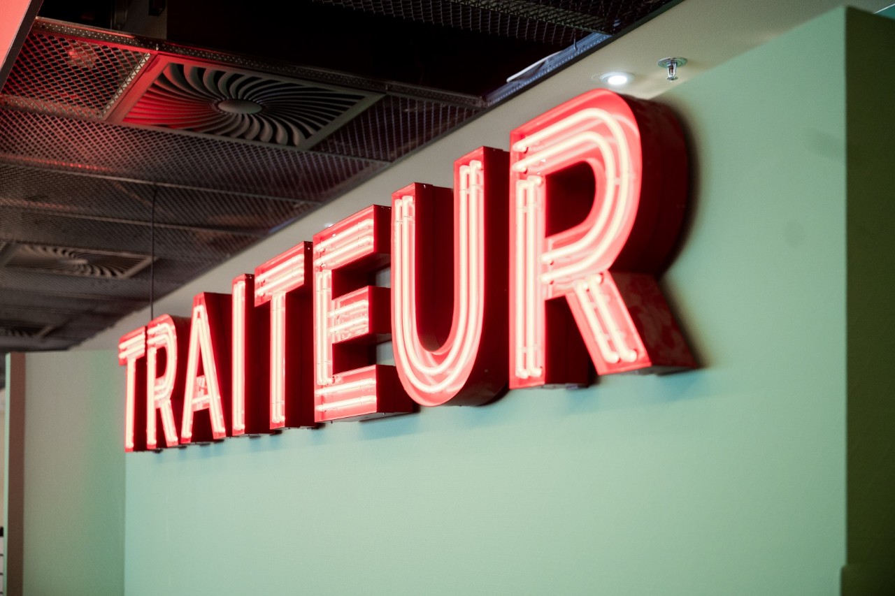 Red Traiteur lettering on green wall.