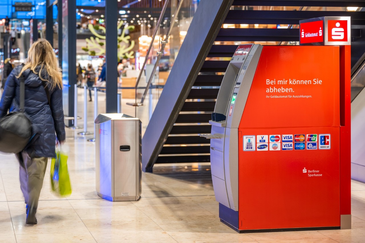 1 person walks past a Berliner Sparkasse ATM.