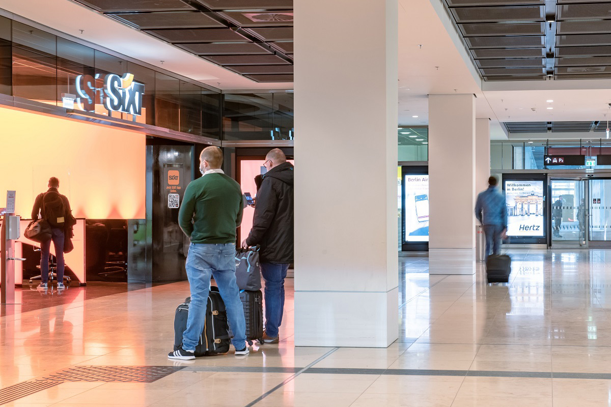 View of the Sixt counter. 2 people waiting.