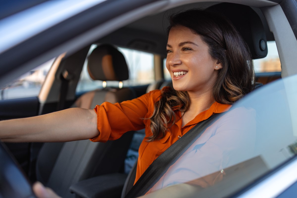 A woman sits at the wheel of a car