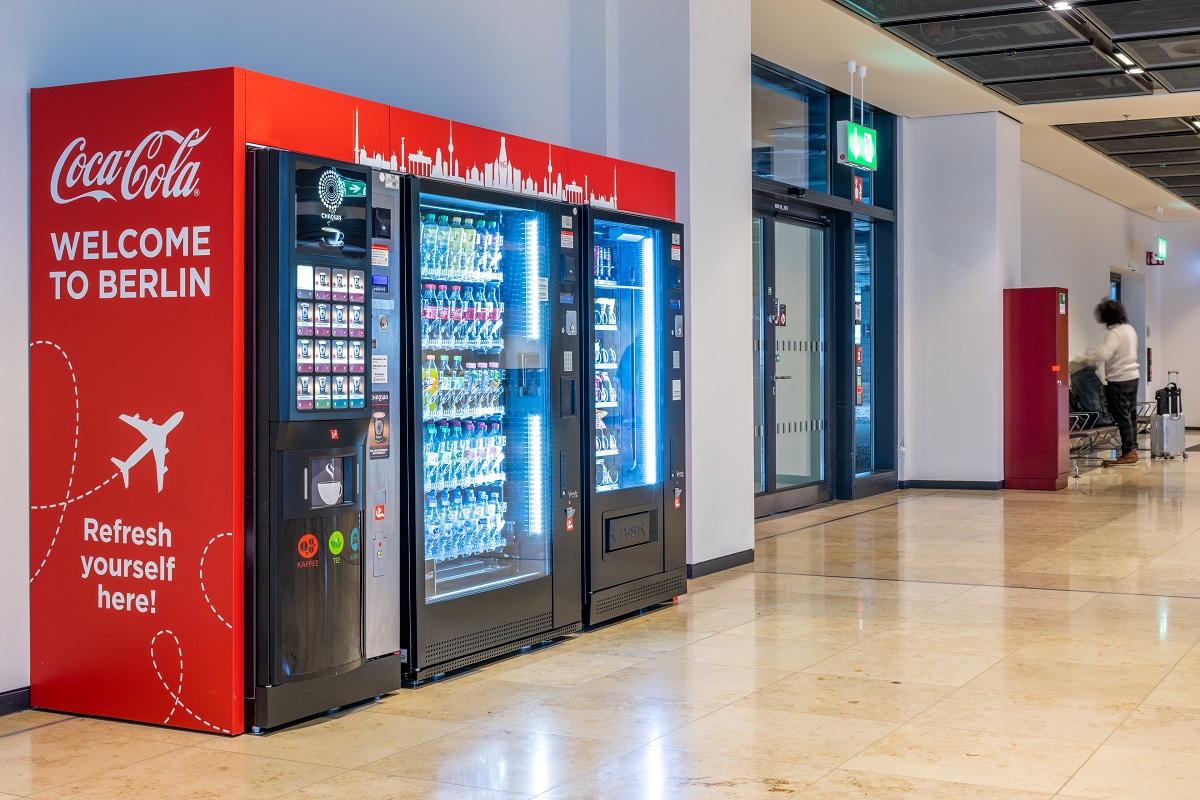 A drinks and snack machine with the label Coca Cola Welcome to Berlin. 