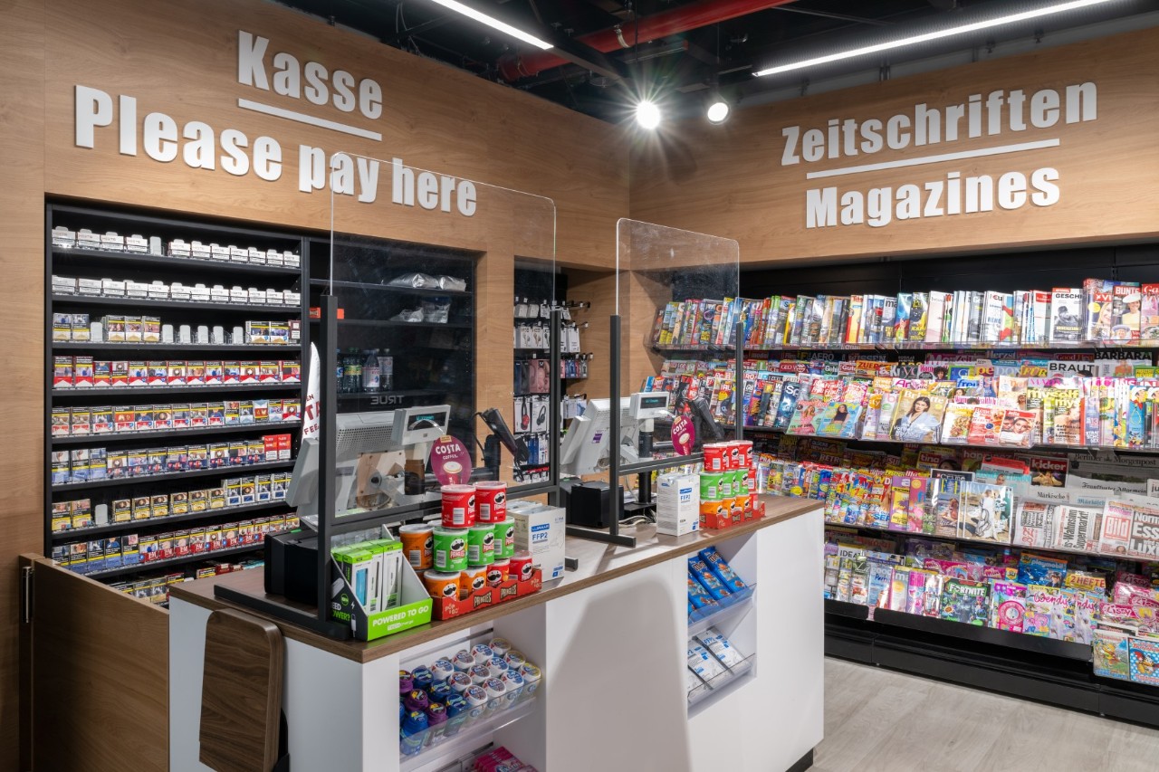  View of the counter. In the background shelves with magazines and cigarettes.