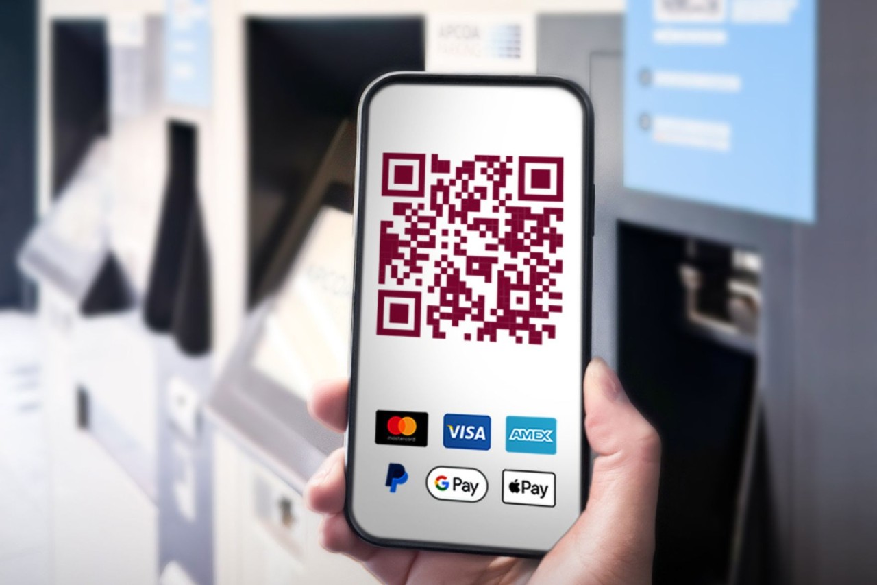 Woman holding a cell phone. The cell phone displays a QR code for paying for a parking ticket.