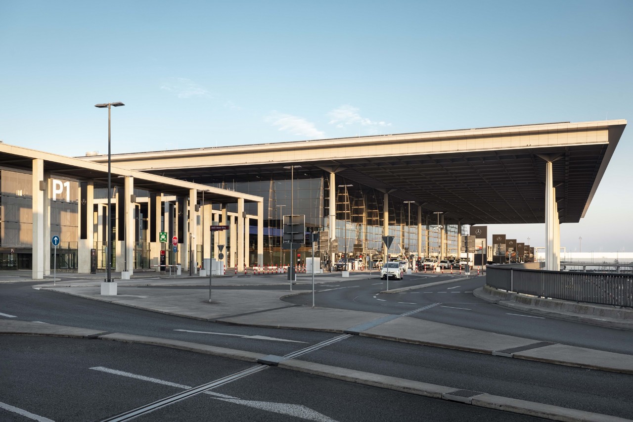 P1 Premium Plus parking garage at Berlin Brandenburg Airport, directly adjacent to Terminal 1. The map shows the access route via Melli-Beese-Ring, the parking garage with 155 spaces, barrier-free access points, and nearby terminals. Symbols indicate special parking areas for people with reduced mobility, women, and families.
