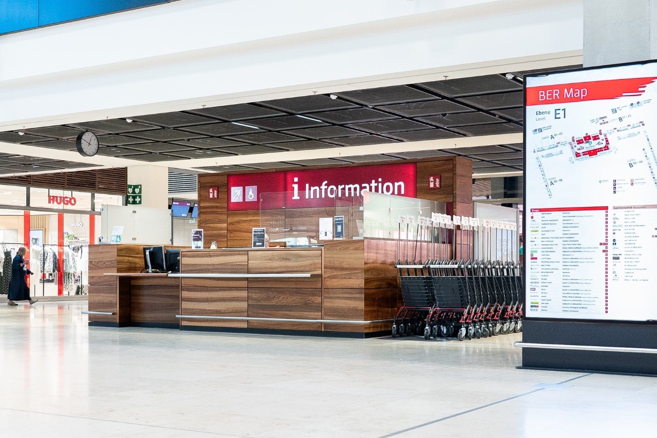 Airport information in the Terminal 1 marketplace. Next to it is an information kiosk. Behind it are shops.