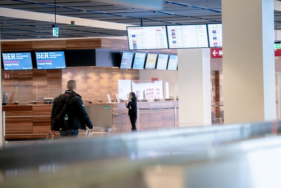 In the front area, the surface of the baggage claim area. In the background the baggage tracing area. 2 people in front of it.
