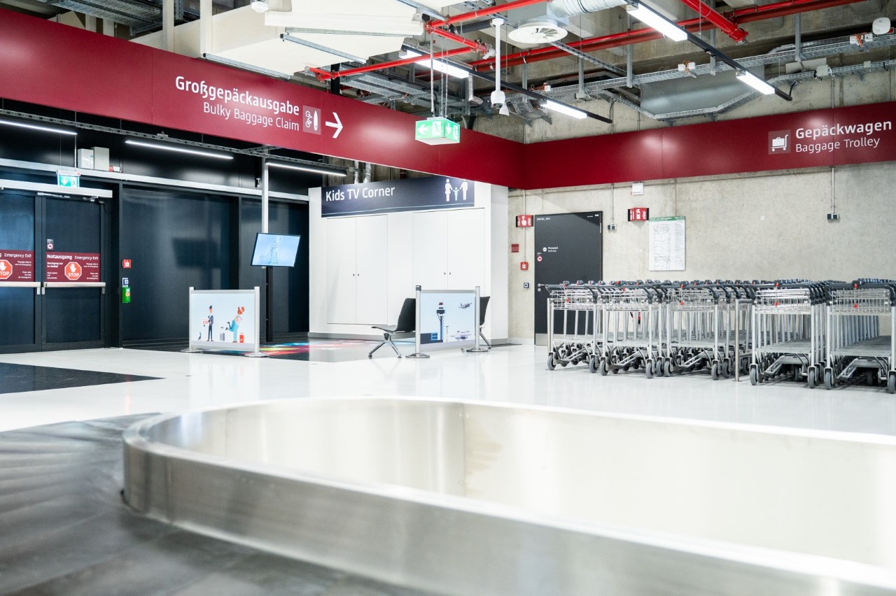 A baggage carousel in Terminal 2. Directly behind it is the children's area. Baggage trolleys are on the right-hand side.