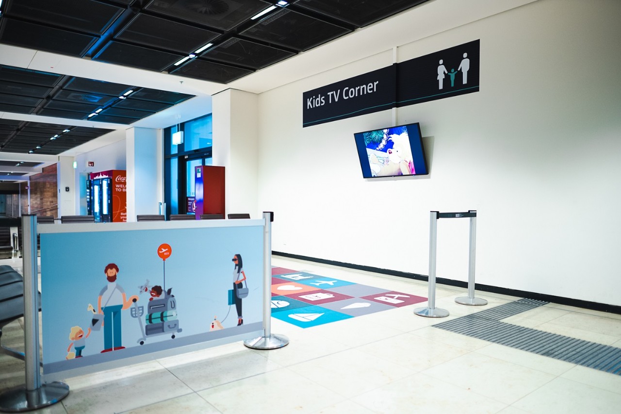 View of the kids' area. A television on the wall. A colorful area in front of it.