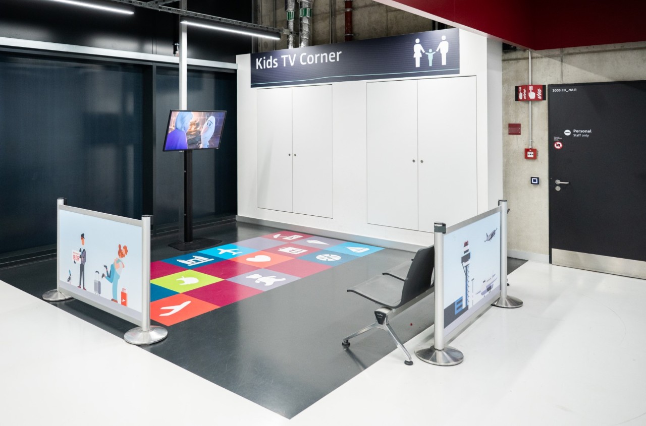 View of the kids' area. A television on the wall. A colorful area in front of it.