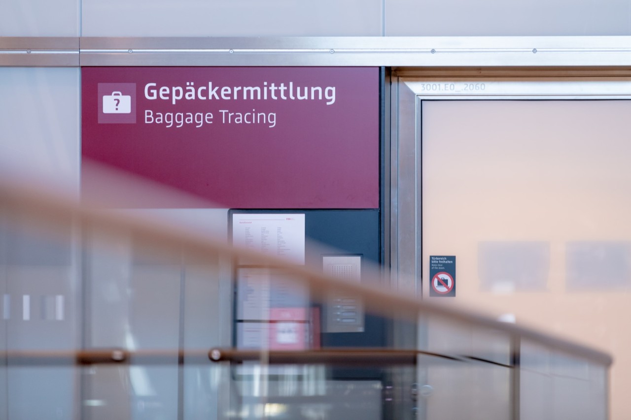 Sign with the inscription “ Baggage tracing”. Next to it is a frosted glass door.