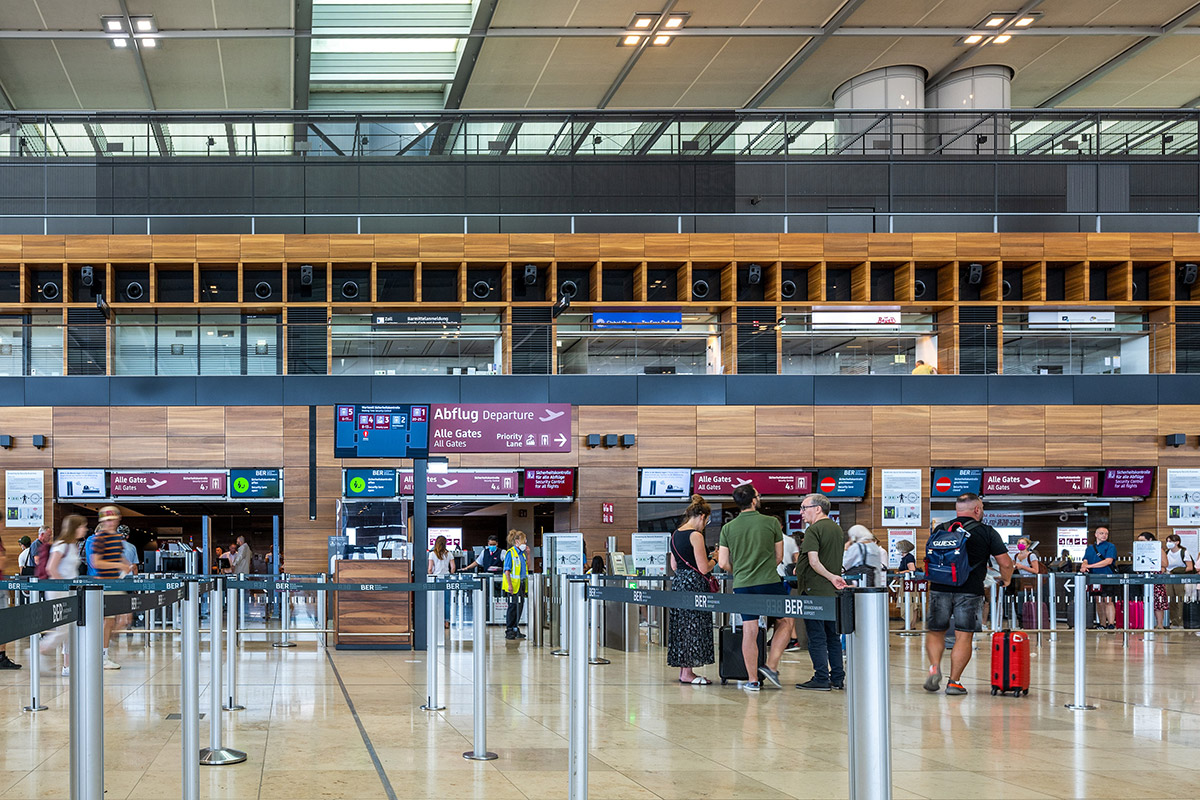 Security screening lanes in Terminal 1 of BER Airport, with monitors above.
