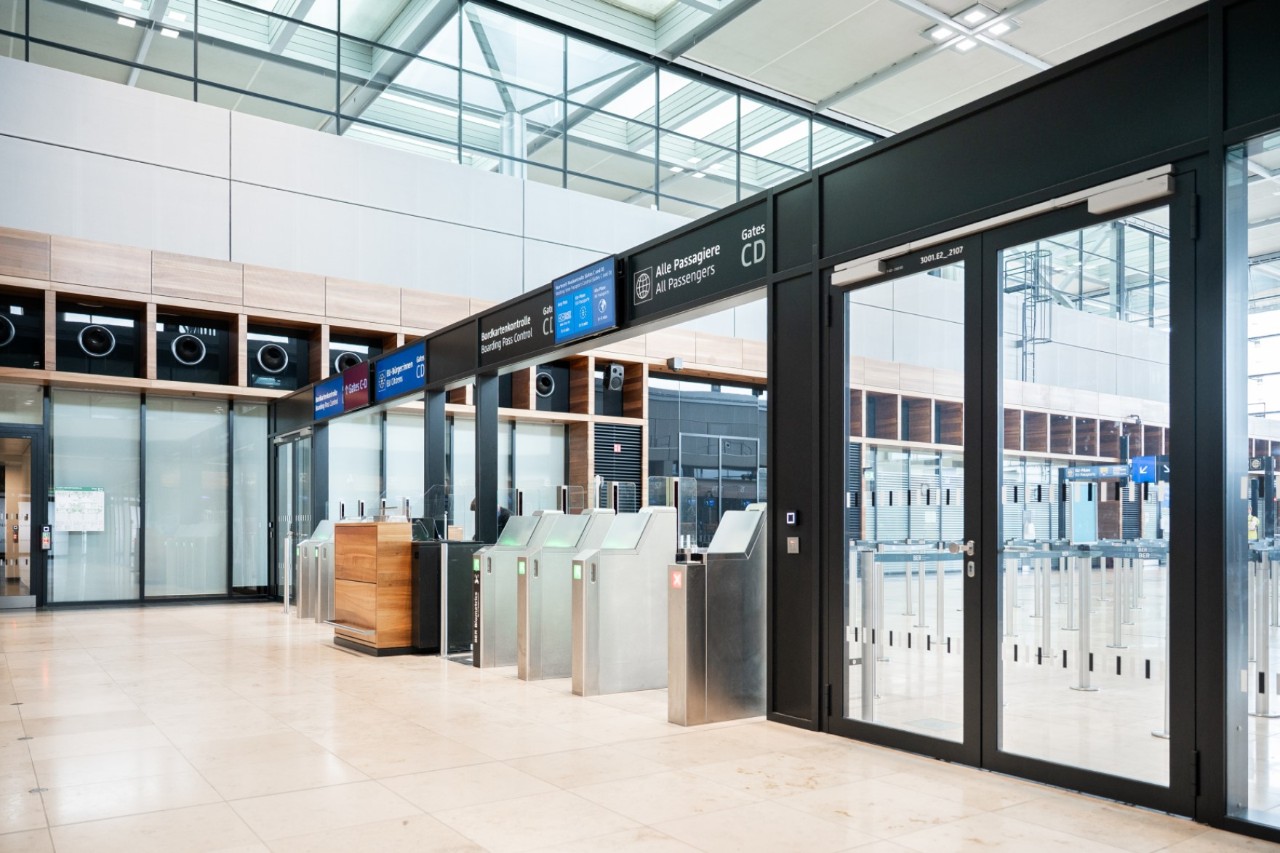 Access control to the central border control area in Terminal 1. Overhead signs indicate gates C and D.