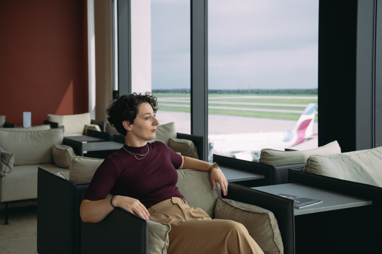Woman sits in a lounge chair and looks out of the window