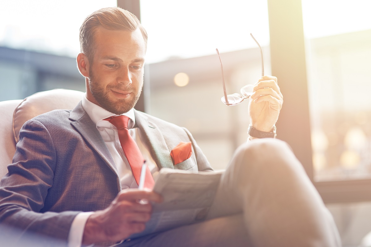 Man in lounge chair reading a newspaper