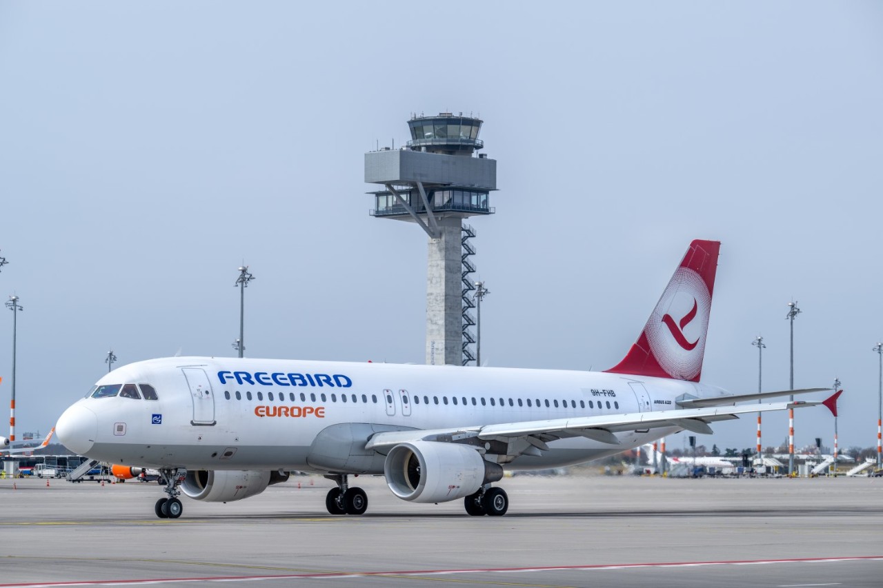 Freebird Airlines Europe aircraft in front of the tower.