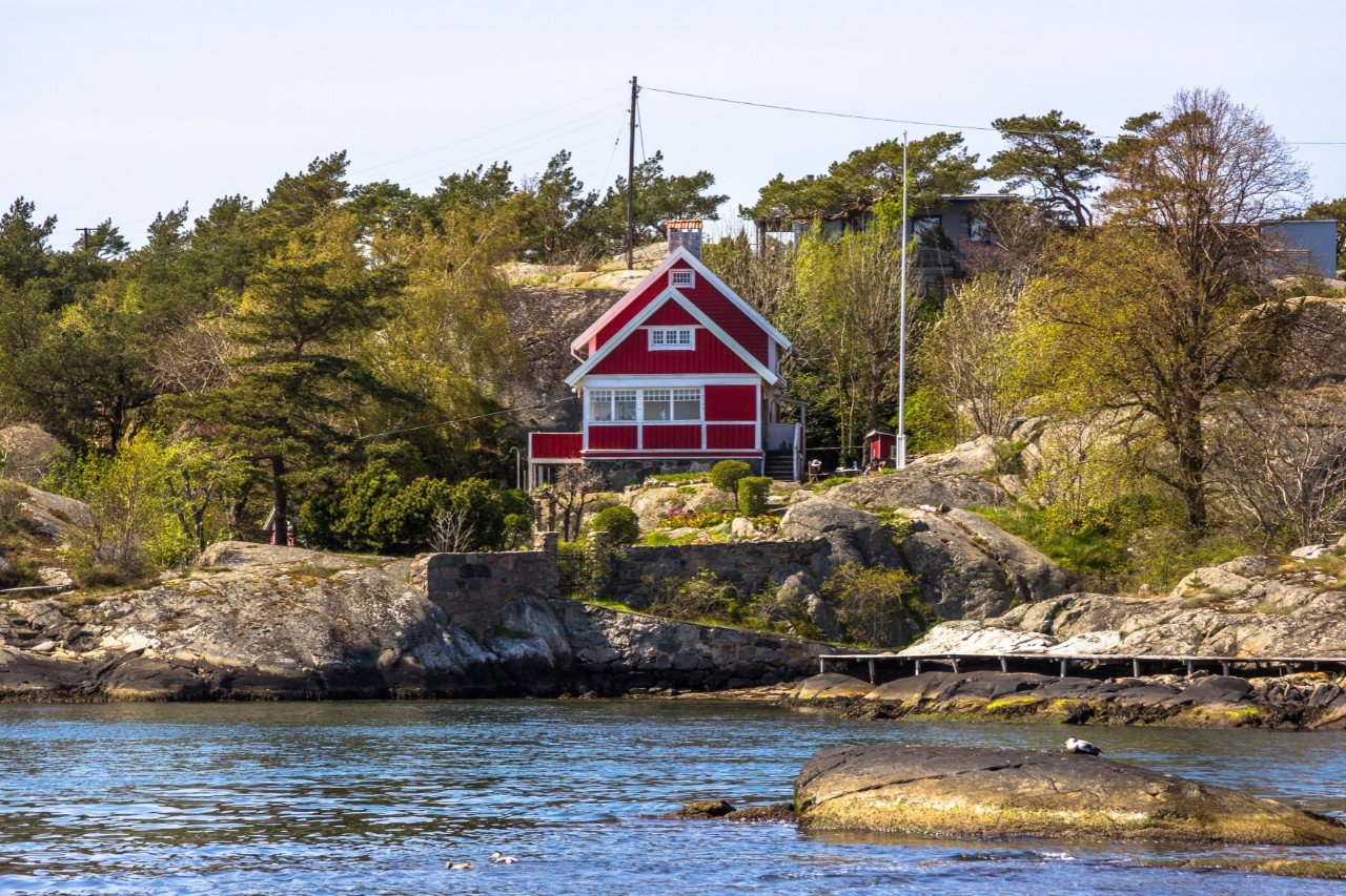 Wooden house on the Brannö Island, red house on the water 