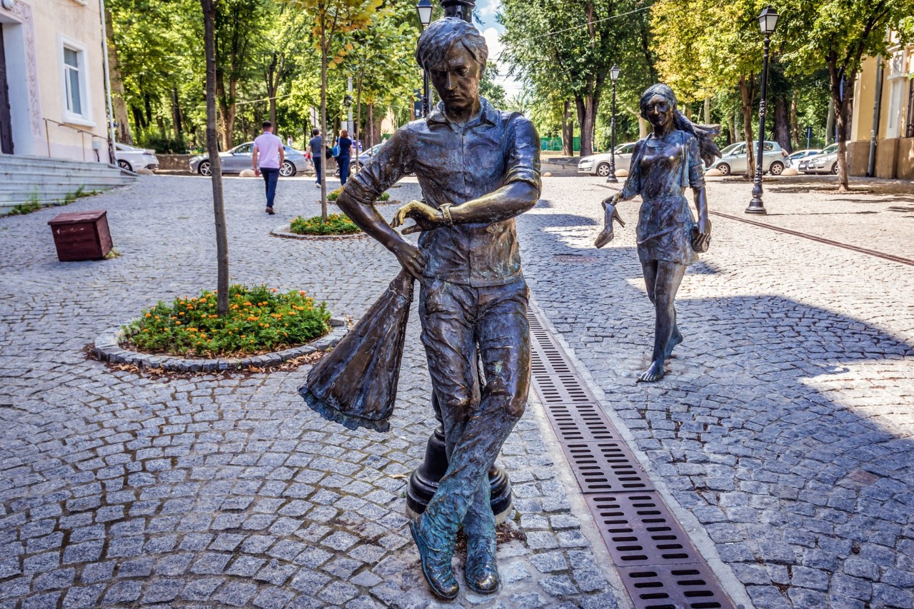 Pedestrian zone, cobblestones, trees in the background, two sculptures 