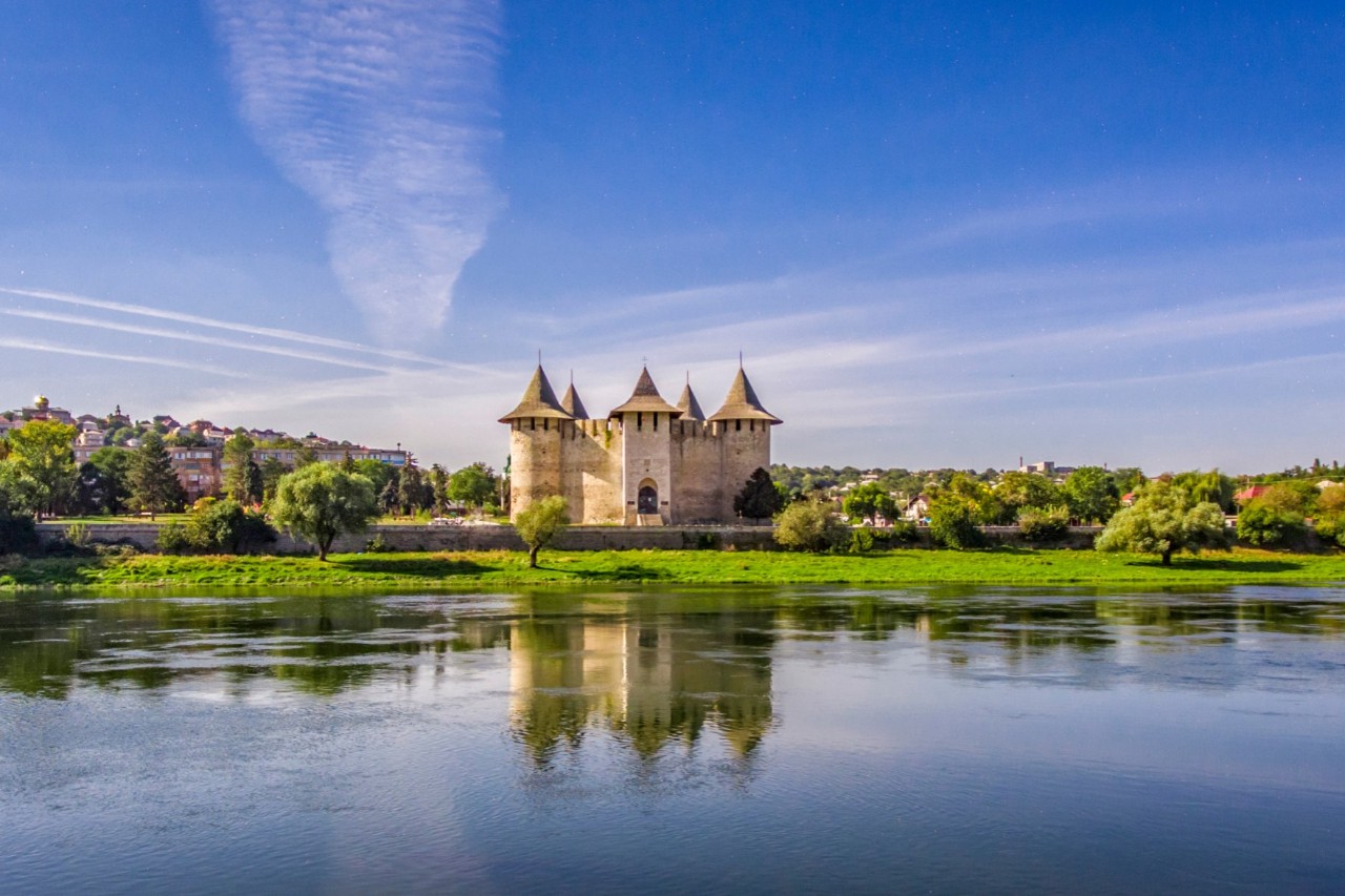 Fortress, late medieval fortification, blue sky, green meadow, river in the foreground 