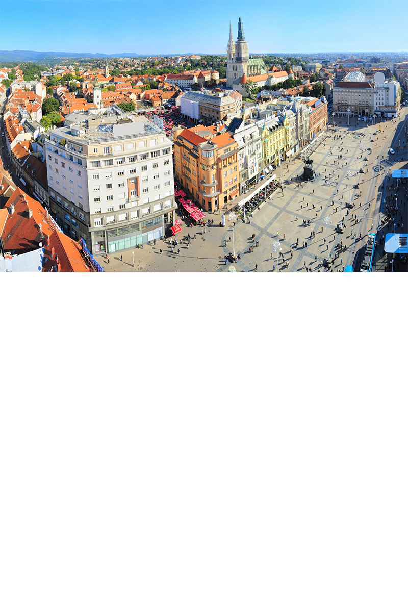View of a large, busy shopping street with lots of buildings all around and a church in the background. © joyt/stock.adobe.com  