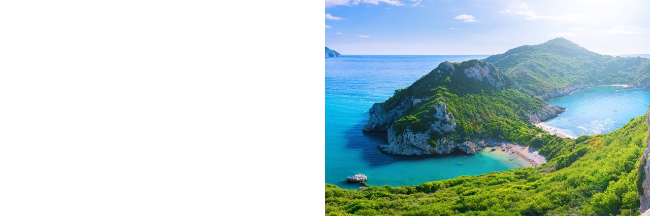 Bathing bay on Corfu. Light blue water and beach. Mountainous terrain.