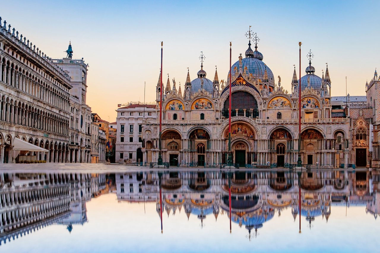 St. Mark's Square, St. Mark's Basilica at sunset, cathedral reflected in the water, square flooded. © Irina Demenkova/stock.adobe.com