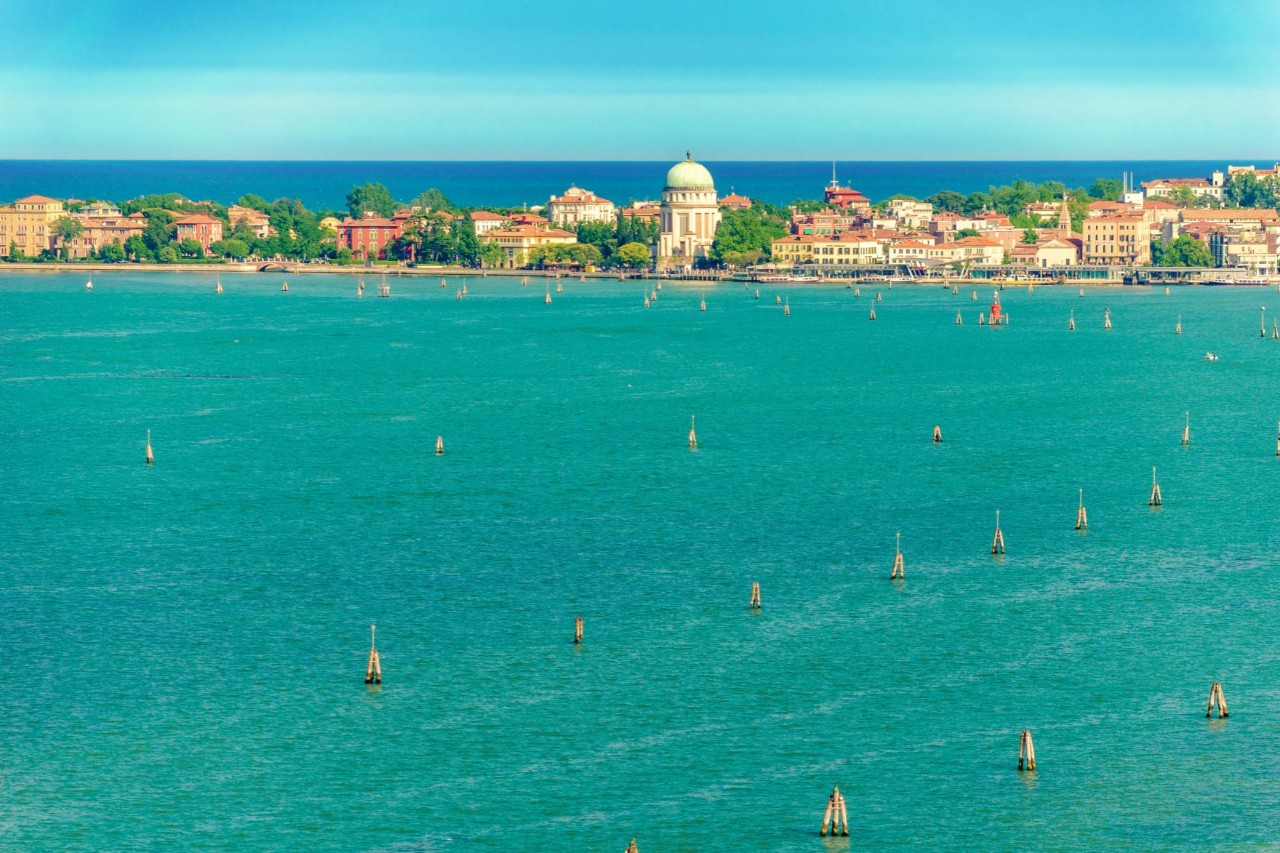 Turquoise water, in the distance the island of Lido with the Tempio Votivo della Pace tower, buildings and trees. © Lichtwolke99/stock.adobe.com