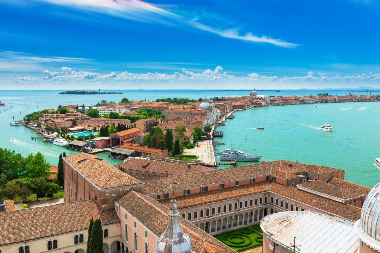 View of the long islands of San Giorgio Maggiore and Giudecca, turquoise water, old buildings, brown roofs. © Ekaterina Belova/stock.adobe.com