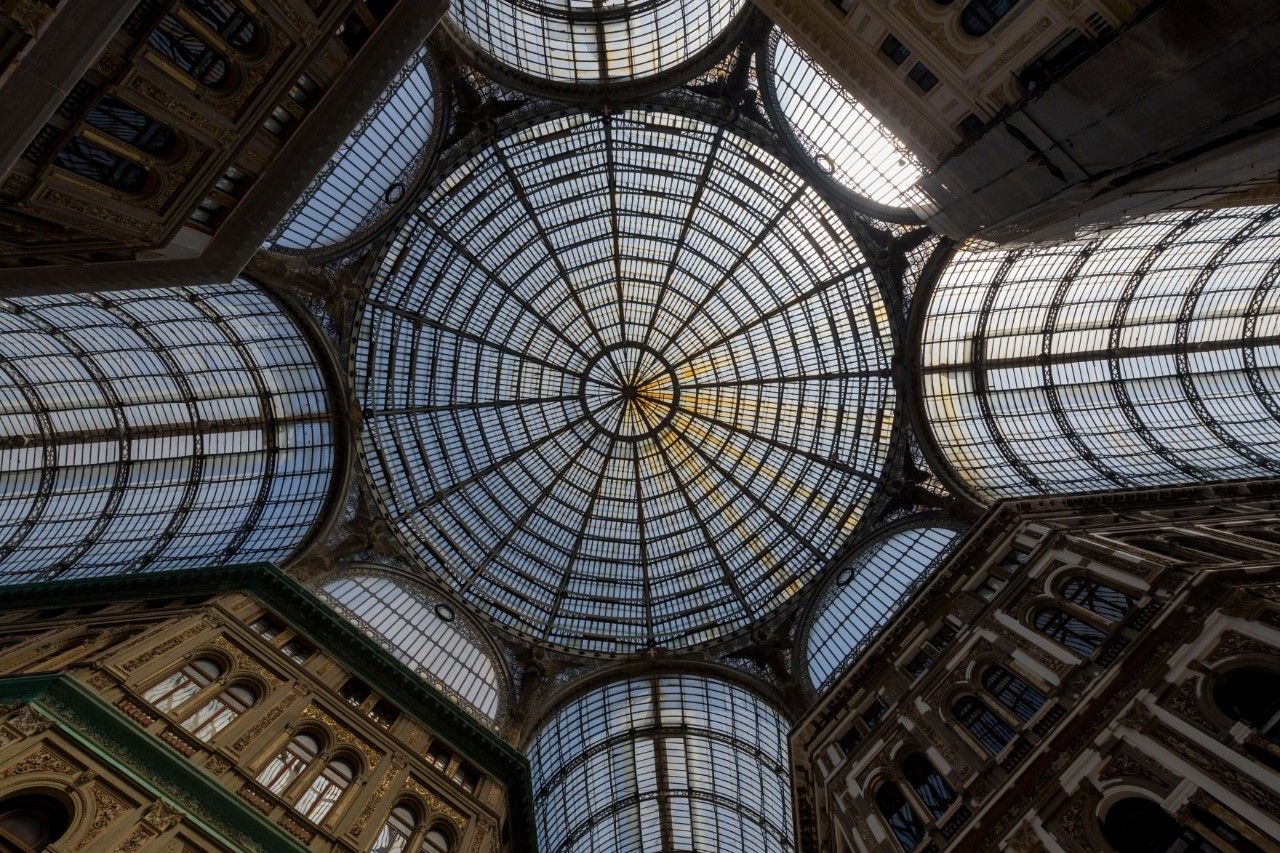 Photo of a shopping arcade ceiling with a glass dome resembling a wheel, with glass columns leading down from the dome. © goyoconde/stock.adobe.com