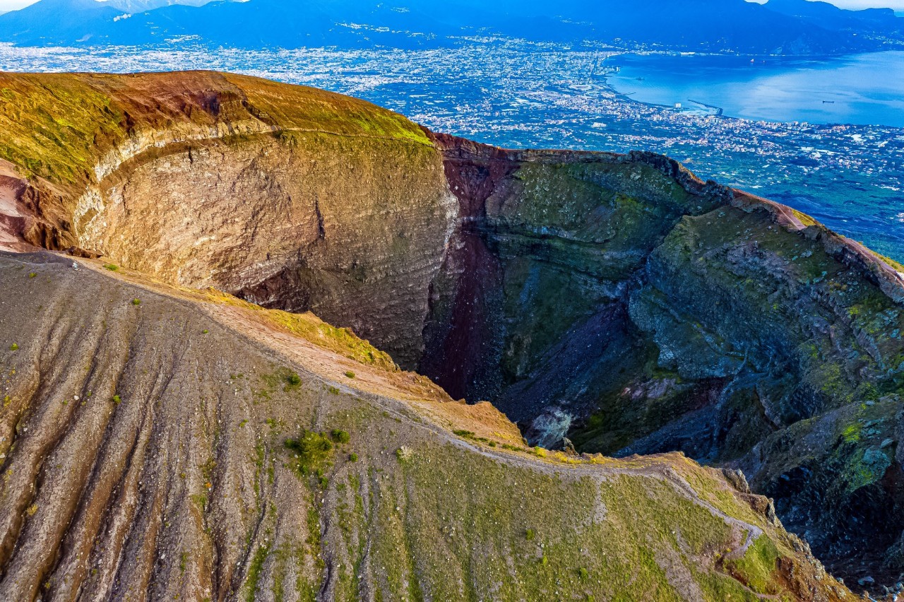 Aerial view of the Vesuvius crater. Naples and the coastline are on the horizon. 