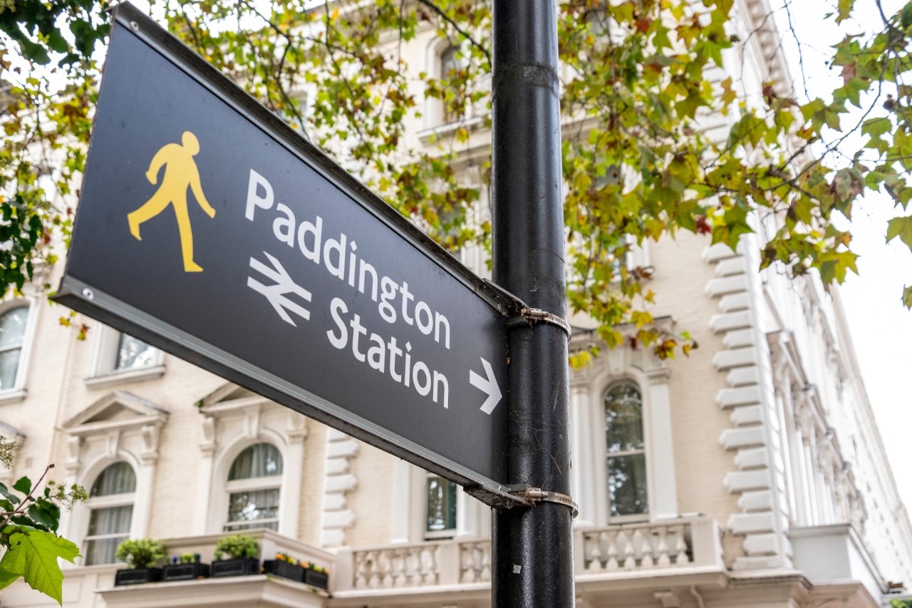 Paddington Station sign with platform in the background.