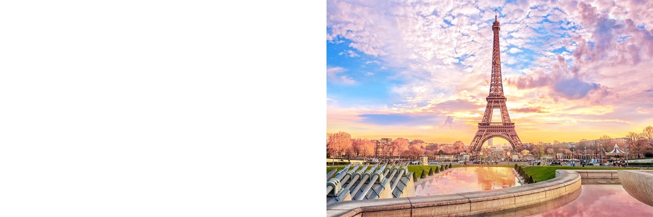 The Eiffel Tower in the evening light. Behind it, the silhouette of Paris.