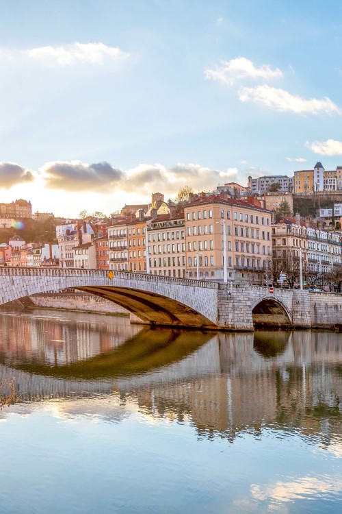 View of Lyon on the river Saône. Old building on a hill. A bridge on the left.