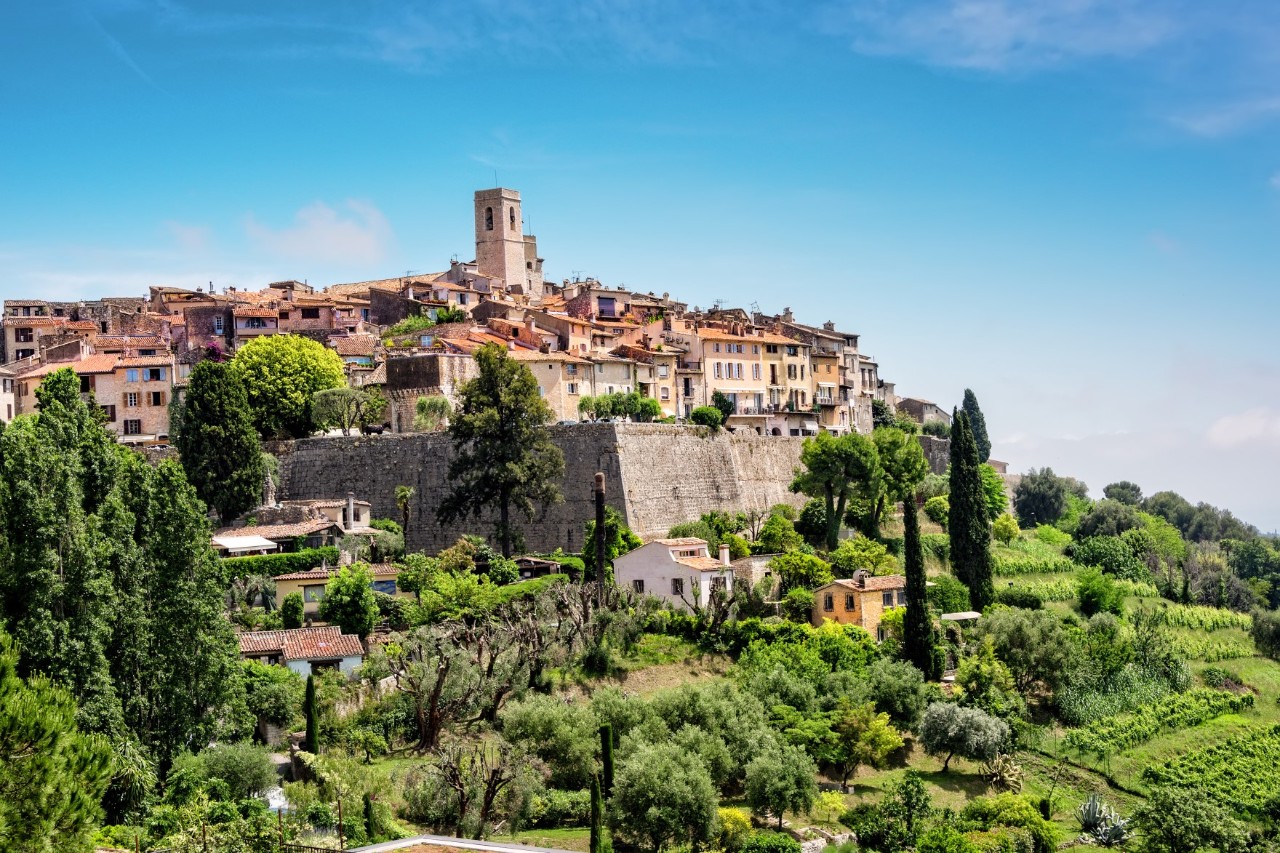Saint-Paul-de-Vence on a hill with town wall and church tower, in the foreground smaller houses in the country © Ruth P.Peterkin/stock.adobe.com