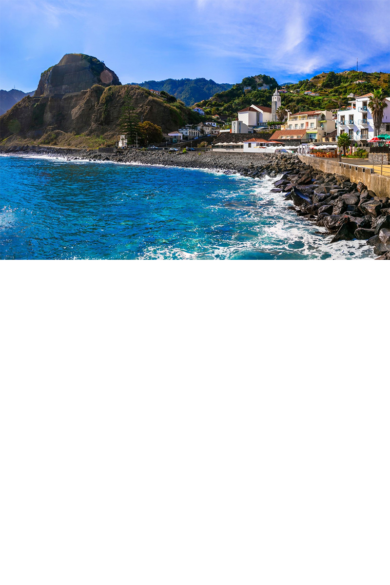 View of the blue sea, rocky mountains in the background, on the right of the picture shoreline stabilisation and a village with white buildings. © Freesurf/stock.adobe.com