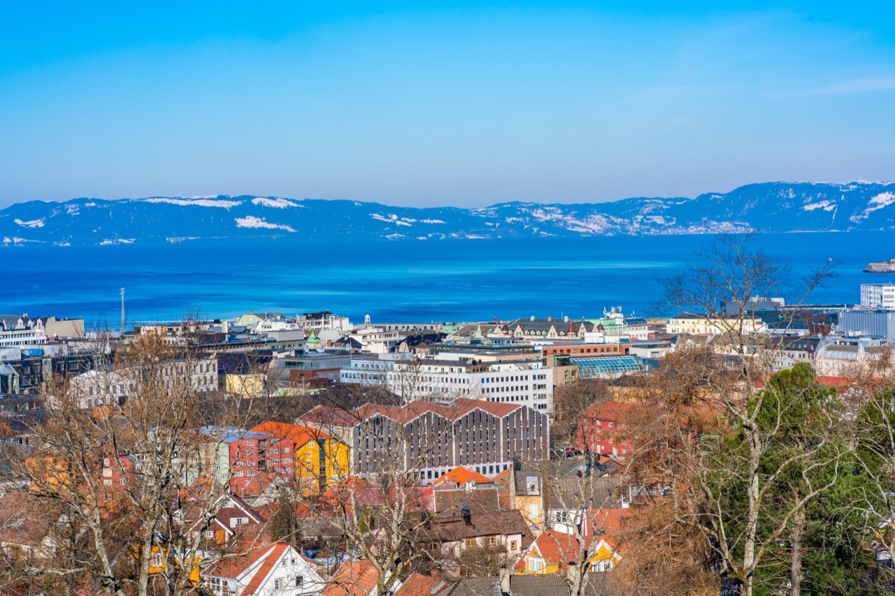 View of the city, the fjord and snow-covered mountains from above. 