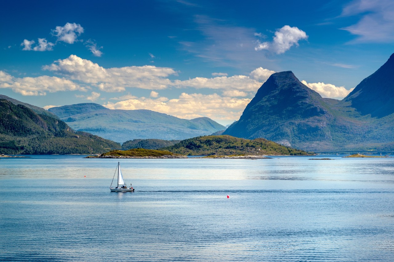 Sailing boat on the water surrounded by mountains. © DirkDaniel/stock.adobe.com 
