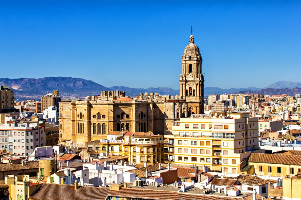 Baroque cathedral with tall tower and ornate façade in sunlight.